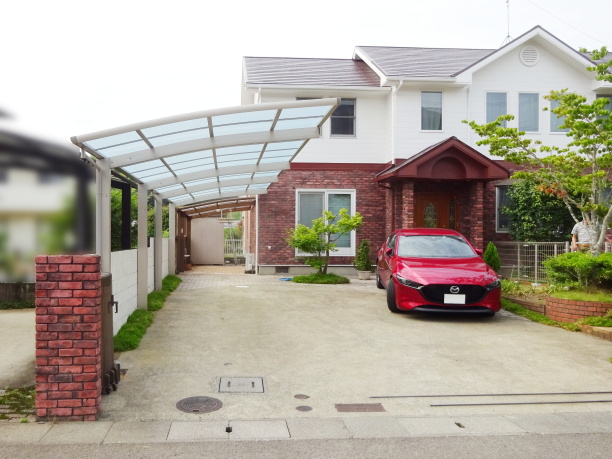 縦２台タイプのカーポートと２色で外壁塗装された住宅