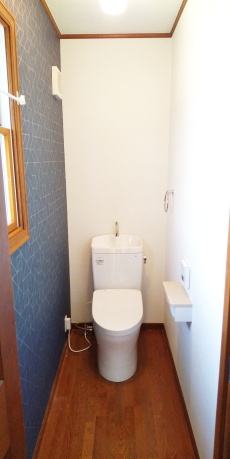 壁クロスの１面に紺色が施された2階トイレ室内
