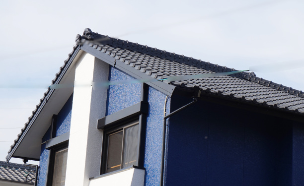 濃いブルーの屋根と、ブラックの雨樋と雨戸